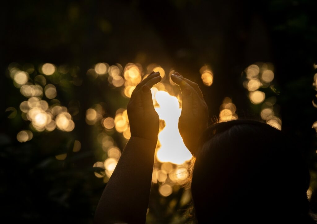 Woman connecting with her intuition and human energy field through mindful awareness.
